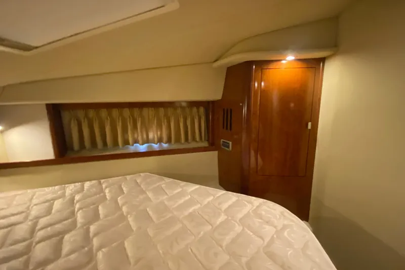 Slide: The Image of Interior cabin of 2006 Sea Ray 38 Sundancer with wood paneling and bed. - 32