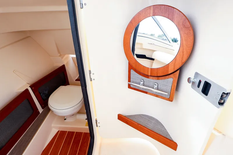 Slide: The Image of 2020 Grady-White Freedom 235 boat interior with toilet and round mirror. - 25