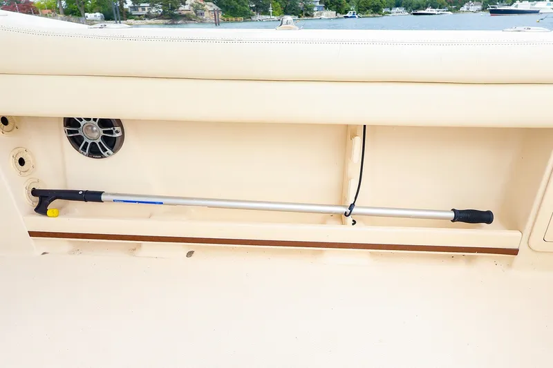 Slide: The Image of Storage compartment on a 2020 Grady-White Freedom 235 boat, featuring a boat hook and speaker. - 21