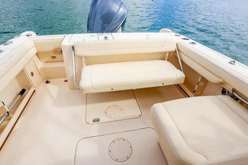 Slide: The Image of 2020 Grady-White Freedom 235 boat interior with beige seating and open water view. - 17