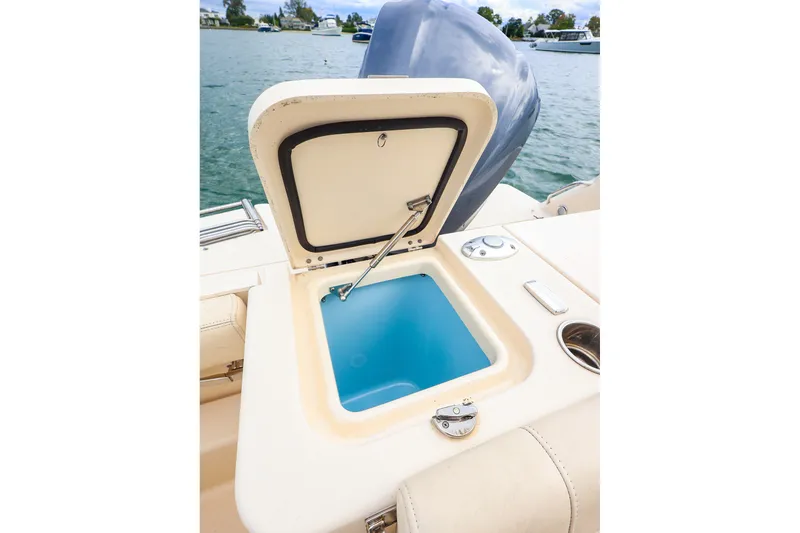 Slide: The Image of Open storage compartment on 2020 Grady-White Freedom 235 boat, near water. - 18