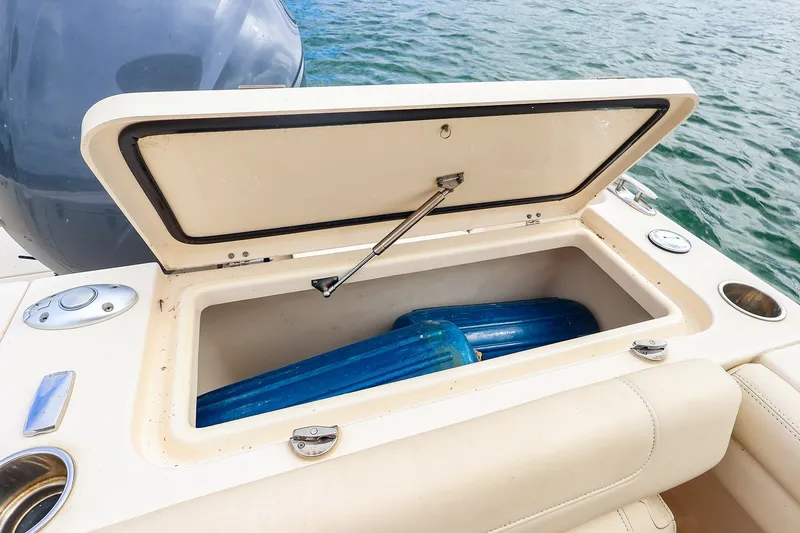 Slide: The Image of Open storage compartment on 2020 Grady-White Freedom 235 boat, with blue fenders inside. - 20