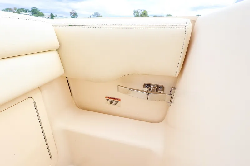 Slide: The Image of 2020 Grady-White Freedom 235 boat interior detail with beige upholstery and metal latch. - 16