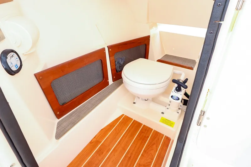 Slide: The Image of 2020 Grady-White Freedom 235 boat interior with marine toilet and wooden flooring. - 24
