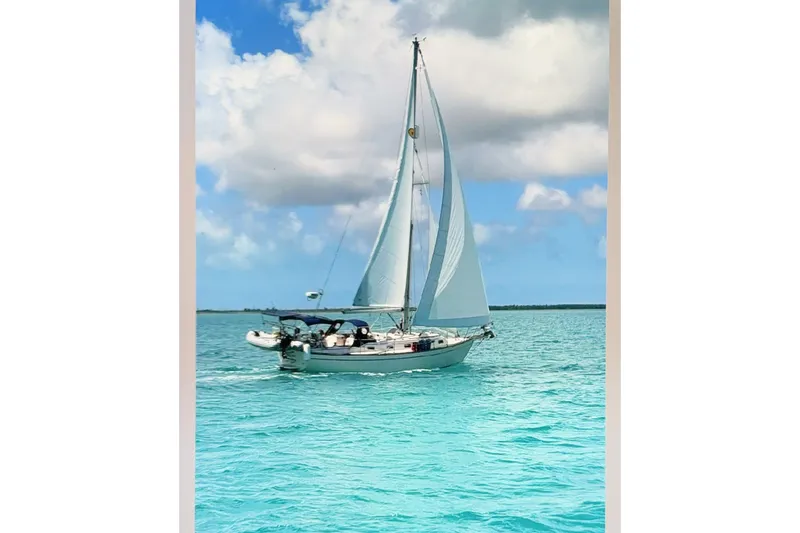 Slide: The Image of Sailboat Island Packet 37 (1997) cruising on turquoise waters under a cloudy sky. - 1