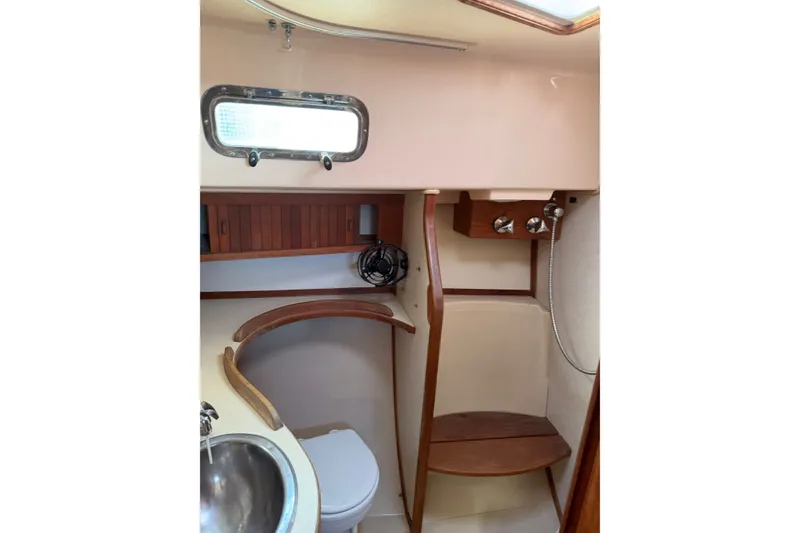 Slide: The Image of 1997 Island Packet 37 yacht bathroom with wooden accents and stainless steel sink. - 16