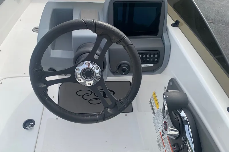 Slide: The Image of Steering wheel and dashboard of 2025 Tahoe T21 boat, featuring modern controls and display. - 2
