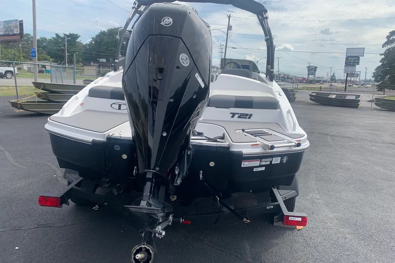 Slide: The Image of 2025 Tahoe T21 boat with outboard motor on a trailer in a parking lot. - 11