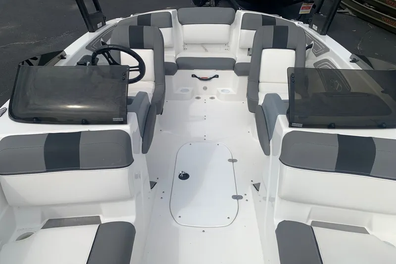 Slide: The Image of 2025 Tahoe T21 boat interior with gray and white seating, steering wheel, and windshield. - 4