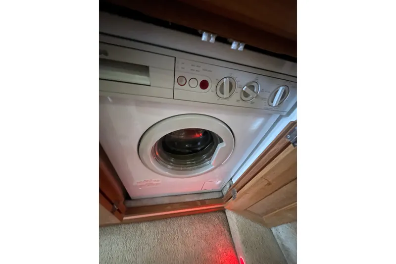 Slide: The Image of Washing machine inside 1995 Bayliner 4788 Pilot House Motoryacht, partially enclosed by wooden cabinetry. - 25