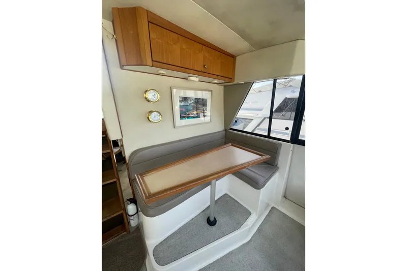 Slide: The Image of 1995 Bayliner 4788 Pilot House Motoryacht interior with dining area, wooden cabinetry, and nautical decor. - 21