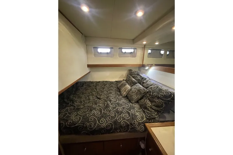 Slide: The Image of Cozy bedroom in 1995 Bayliner 4788 Pilot House Motoryacht with patterned bedding and soft lighting. - 27