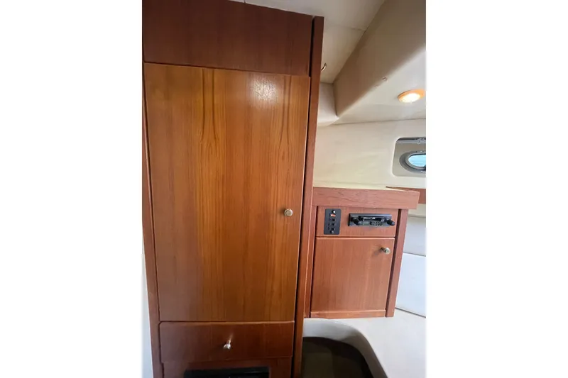 Slide: The Image of 1995 Bayliner 4788 Pilot House Motoryacht interior with wooden cabinetry and control panel. - 34