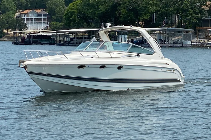 Slide: The Image of 2001 Formula 370 Super Sport boat cruising on a lake near docks and trees. - 44