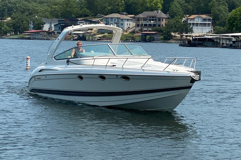 Slide: The Image of 2001 Formula 370 Super Sport boat cruising on a scenic lake with waterfront homes. - 45