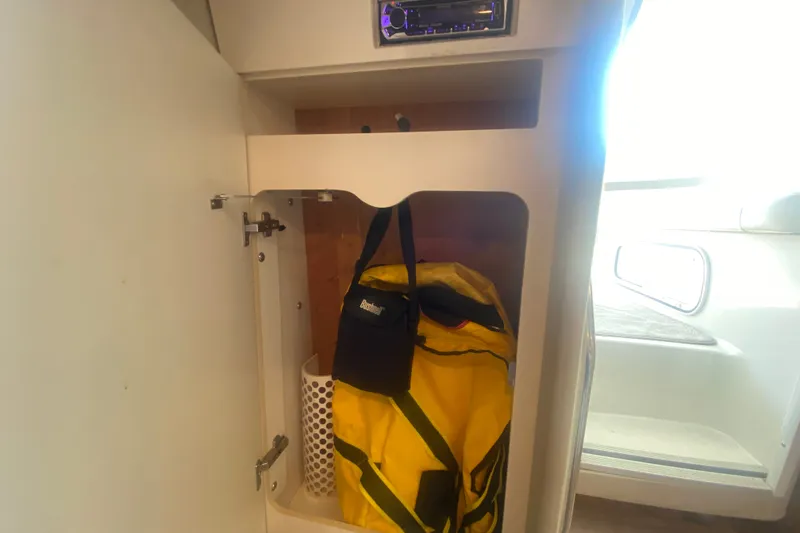 Slide: The Image of Cabinet storage inside a 2001 Formula 370 Super Sport boat, featuring a yellow bag. - 35
