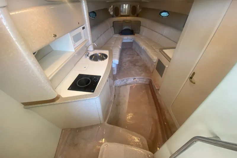 Slide: The Image of Interior of a 2001 Formula 370 Super Sport boat, featuring a compact kitchen and seating area. - 26