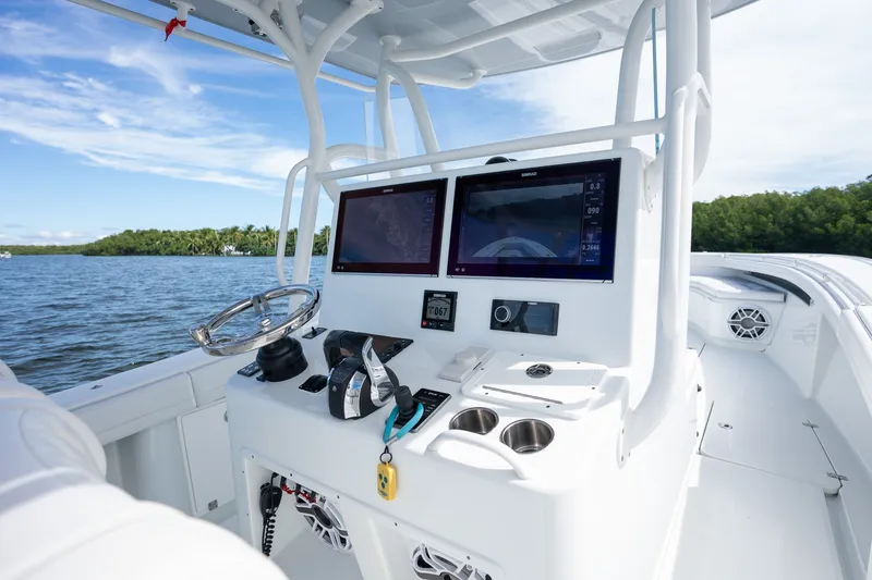 Slide: The Image of 2021 Yellowfin 36 Offshore boat dashboard with dual screens on a sunny day. - 24