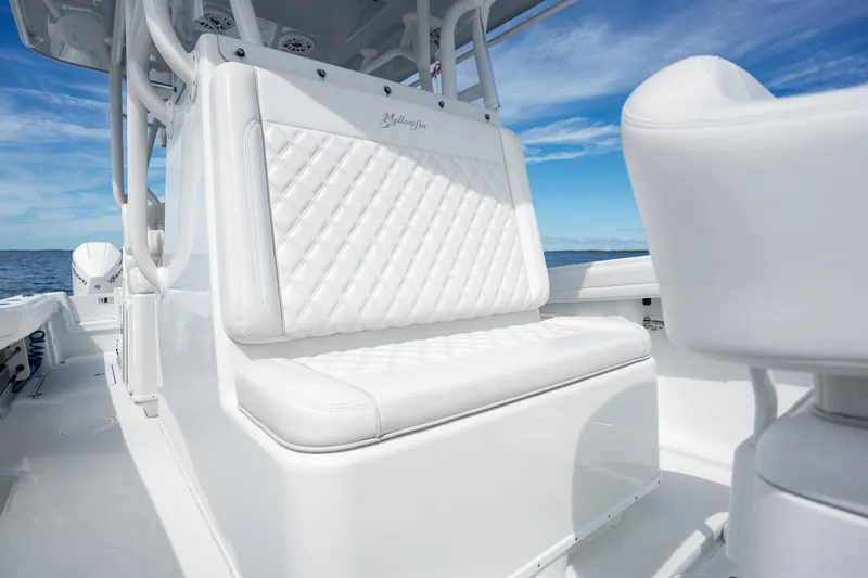 Slide: The Image of 2021 Yellowfin 36 Offshore boat with white cushioned seating, ocean backdrop. - 27