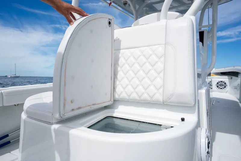 Slide: The Image of 2021 Yellowfin 36 Offshore boat with open storage compartment, white seating, and ocean backdrop. - 32