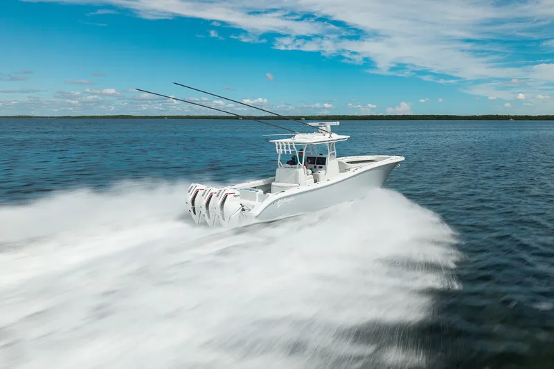 Slide: The Image of 2021 Yellowfin 36 Offshore boat speeding on open water under a clear blue sky. - 14