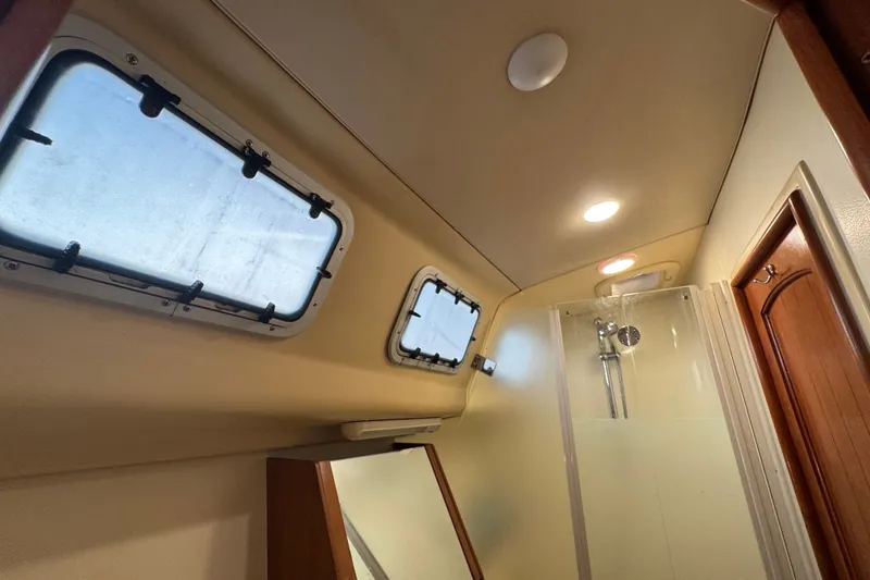 Slide: The Image of Interior of a 2009 Hunter 49 yacht bathroom with shower and porthole windows. - 47
