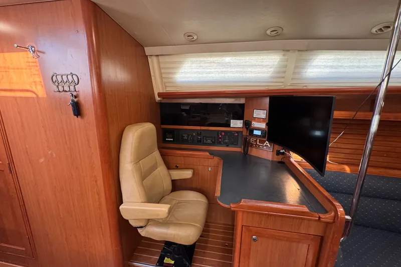 Slide: The Image of Interior of a 2009 Hunter 49 yacht with navigation station and beige chair. - 24