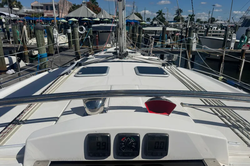 Slide: The Image of Deck view of a 2009 Hunter 49 sailboat docked at a marina under clear skies. - 119