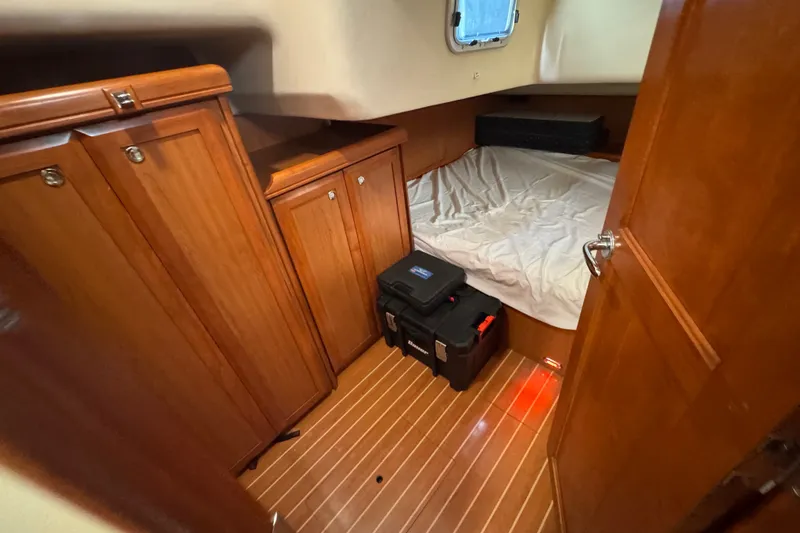 Slide: The Image of Cozy cabin interior of 2009 Hunter 49 yacht with wooden cabinets and bed. - 58