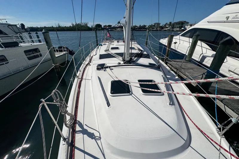 Slide: The Image of 2009 Hunter 49 sailboat docked at marina, surrounded by other boats. - 95