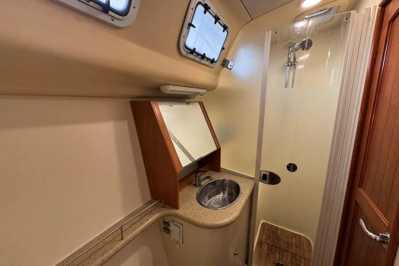 Slide: The Image of 2009 Hunter 49 yacht bathroom with sink, mirror, and enclosed shower. - 48