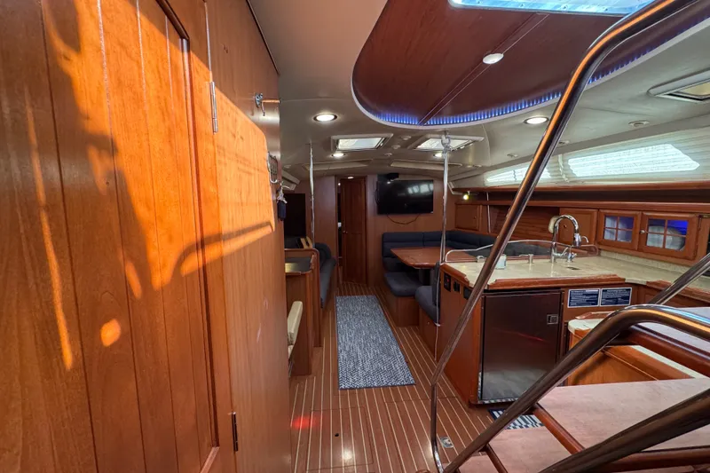 Slide: The Image of Luxurious 2009 Hunter 49 yacht interior with wood finish, modern kitchen, and cozy seating area. - 61
