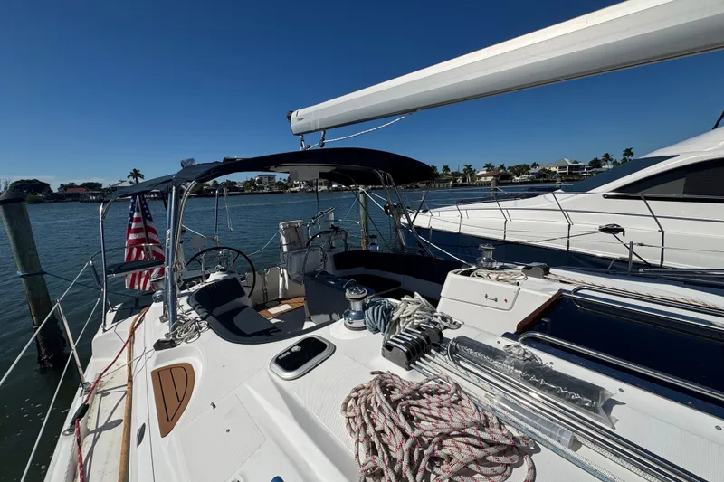 Slide: The Image of Sailboat Hunter 49, 2009 model, docked with American flag, sunny day, waterfront homes. - 103