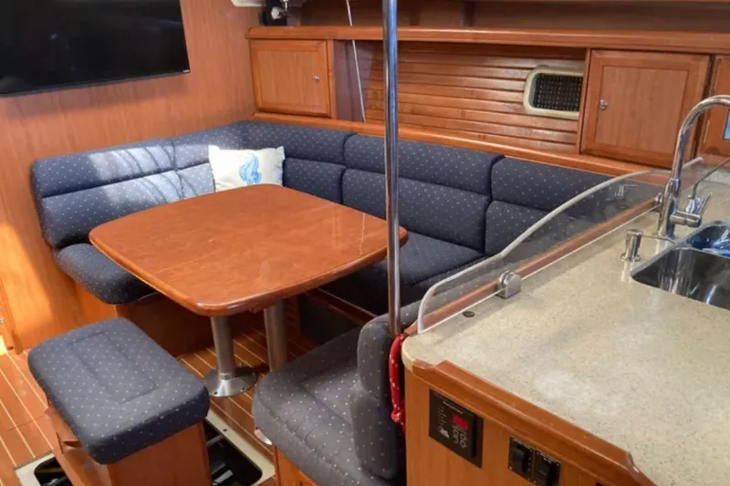 Slide: The Image of 2009 Hunter 49 yacht interior with cozy dining area and modern kitchen amenities. - 16