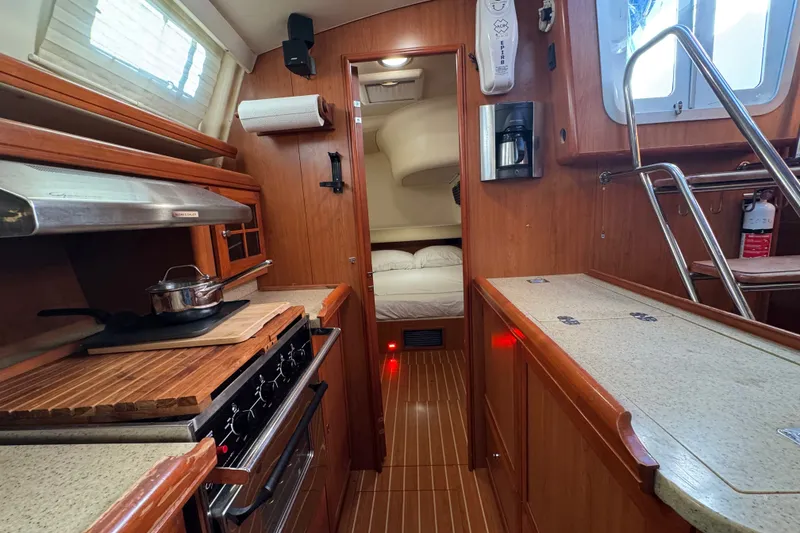 Slide: The Image of Interior of a 2009 Hunter 49 yacht featuring a cozy kitchen and sleeping area. - 18
