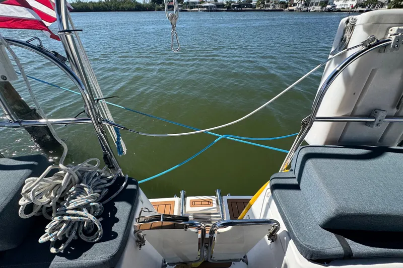Slide: The Image of Rear view of a 2009 Hunter 49 sailboat with ropes and water backdrop. - 81