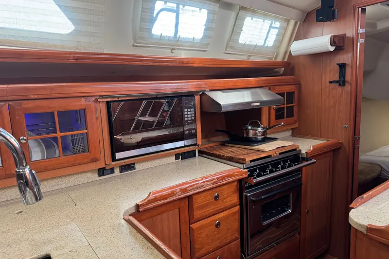Slide: The Image of Luxurious 2009 Hunter 49 yacht kitchen with wooden cabinetry and modern appliances. - 64