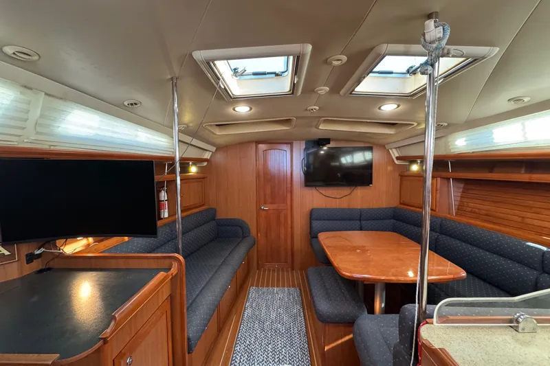 Slide: The Image of Luxurious interior of a 2009 Hunter 49 yacht with wood finishes and seating area. - 25