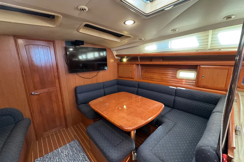 Slide: The Image of Interior of 2009 Hunter 49 yacht with wood paneling, dining area, and mounted TV. - 27