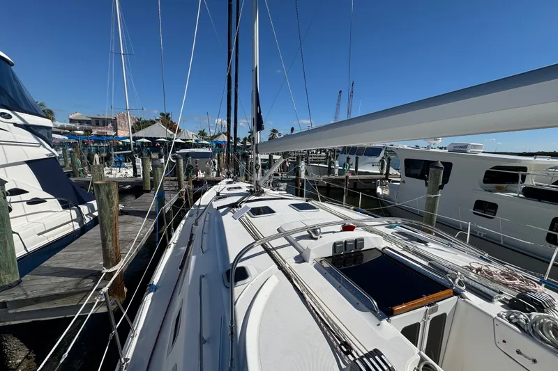 Slide: The Image of 2009 Hunter 49 sailboat docked at marina, surrounded by other boats under clear blue sky. - 88