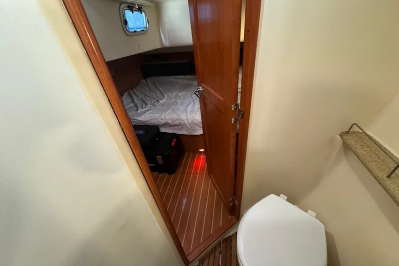 Slide: The Image of Interior of 2009 Hunter 49 yacht showing cabin and bathroom with wooden flooring. - 56