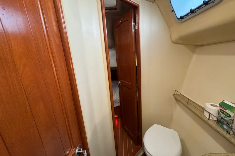 Slide: The Image of 2009 Hunter 49 yacht bathroom interior with wooden door and compact amenities. - 55