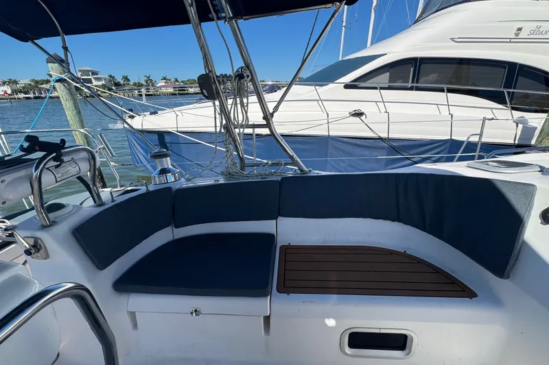 Slide: The Image of Cockpit of a 2009 Hunter 49 sailboat with cushioned seating and marina view. - 77