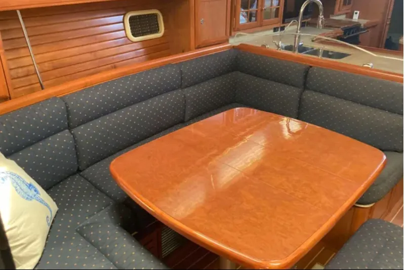 Slide: The Image of Luxurious 2009 Hunter 49 yacht interior with elegant wood table and cushioned seating. - 15