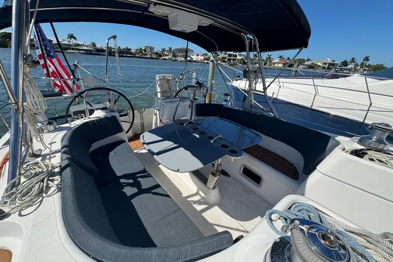 Slide: The Image of Cockpit of a 2009 Hunter 49 sailboat with seating and steering wheel, docked by the water. - 111