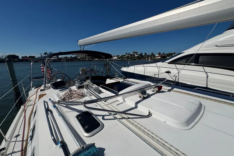 Slide: The Image of 2009 Hunter 49 sailboat docked, featuring spacious deck and clear blue sky. - 102
