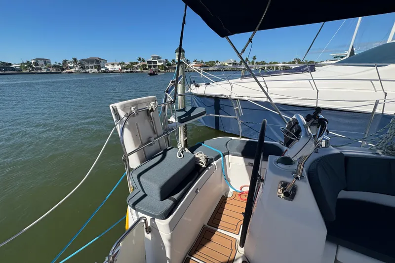 Slide: The Image of Cockpit of a 2009 Hunter 49 sailboat docked by waterfront homes. - 80