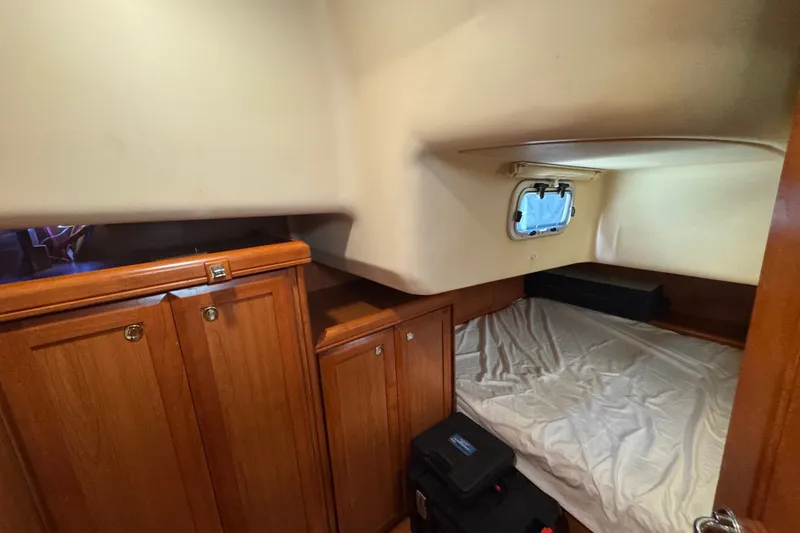 Slide: The Image of Cozy cabin interior of 2009 Hunter 49 sailboat with wooden cabinets and a small window. - 59