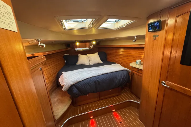 Slide: The Image of Luxurious 2009 Hunter 49 yacht cabin with cozy bed, wooden interior, and skylights. - 32