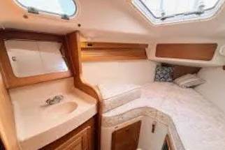 Slide: The Image of Cozy interior cabin of a 2000 Catalina 380 sailboat with bed and sink. - 13